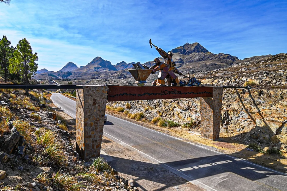 Portal de acceso a La Carolina, con la escultura minera y las sierras de fondo